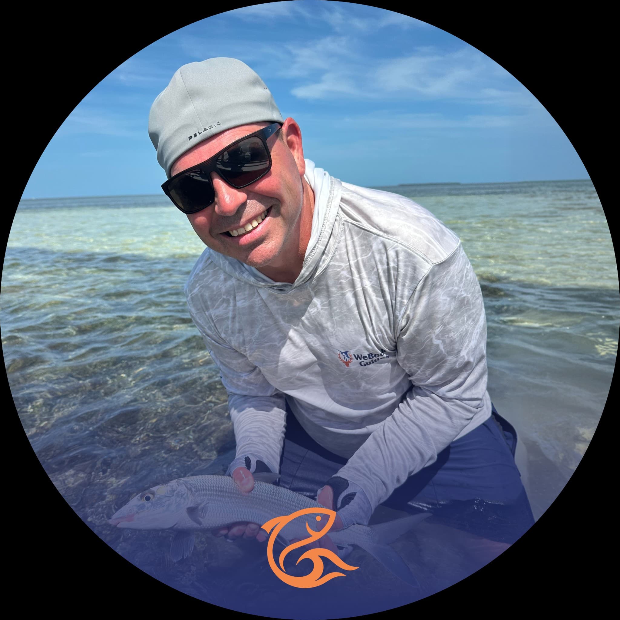 Sean Moriarty holding a fish in shallow tropical water